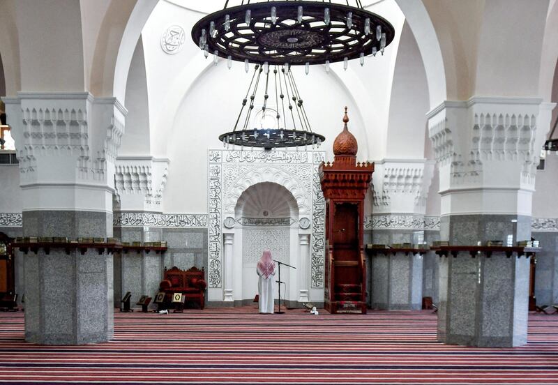 Imam Mohammed, muezzin of the Jaffali mosque in Saudi Arabia's Red Sea coastal city of Jeddah, announces the prayer call at the mosque which is closed due to a government decree as part of efforts to combat the COVID-19 coronavirus pandemic, during the Muslim holy month of Ramadan on April 28, 2020. (Photo by AMER HILABI / AFP)