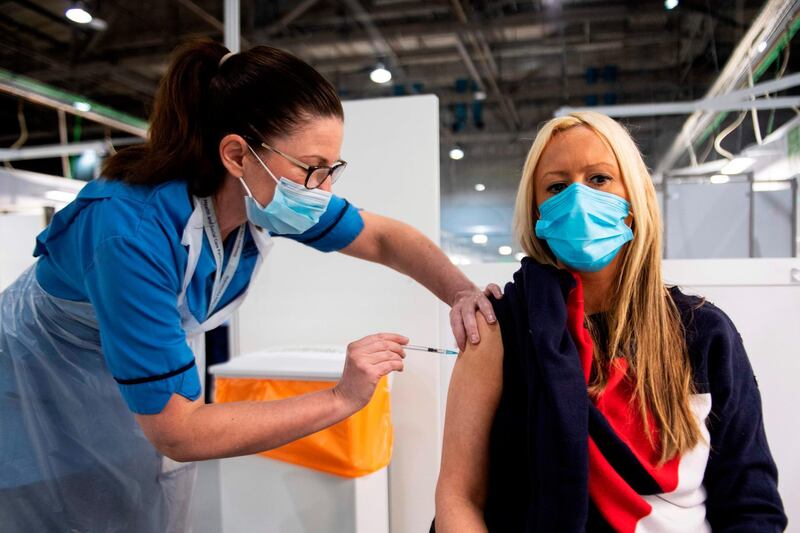 Immunisation Nurse Debbie Briody administers the Pfizer/BioNtech Covid-19 vaccine to Staff Nurse Amanda Thompson at the NHS Louisa Jordan temporary hospital at the SEC Campus in Glasgow, Scotland on January 23, 2021.   / AFP / Andy Buchanan
