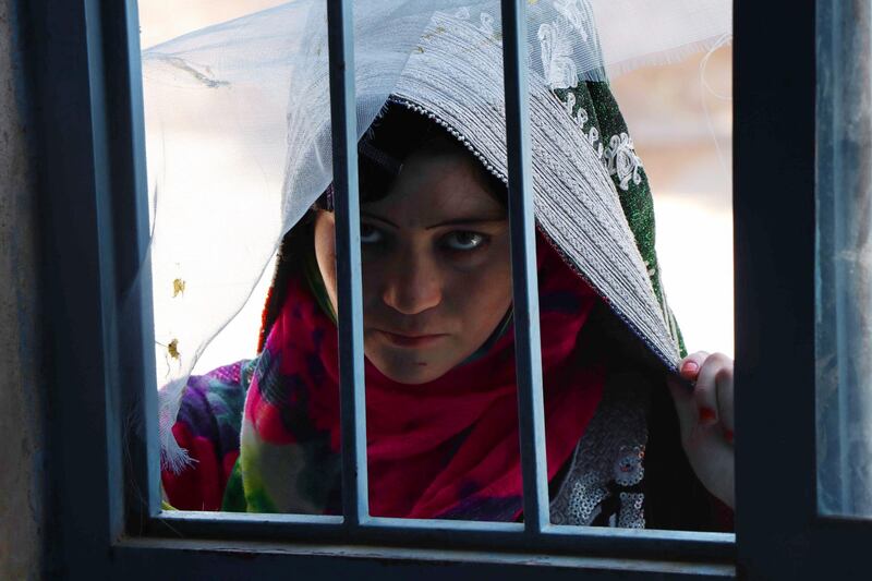 An Afghan woman waits to receives medicines in Herat, Afghanistan. EPA