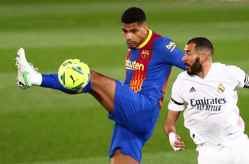 Real Madrid's Karim Benzema in action with Barcelona's Ronald Araujo. Reuters