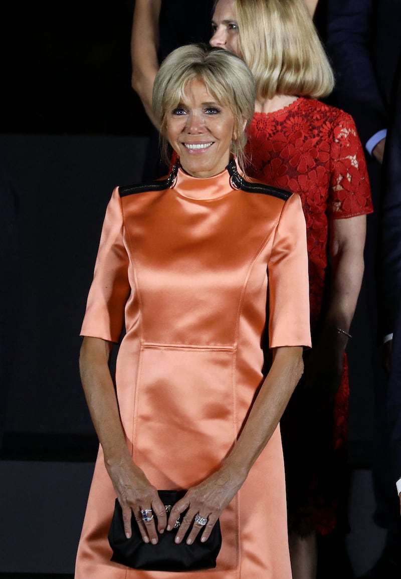 Brigitte, wearing an orange satin Louis Vuitton dress, visits Japan on June 28, 2019. AFP