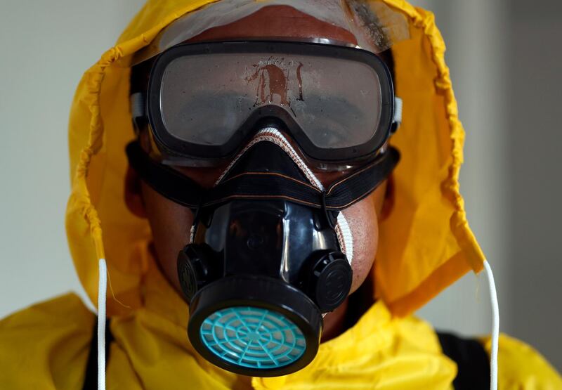 A Yemeni worker wears a protective suit to disinfect an office in Sanaa.  EPA
