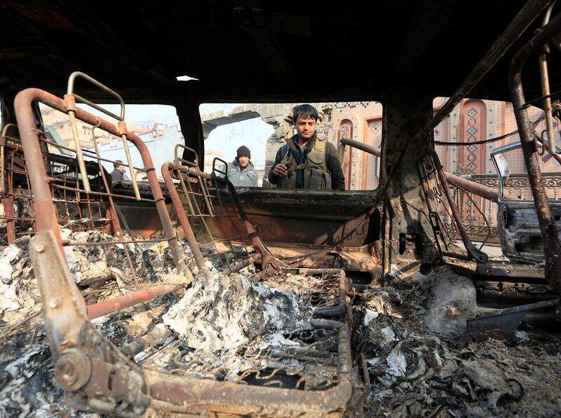 Policemen inspect a burnt car after a terror attack in Jalalabad, Afghanistan. Parwiz / Reuters