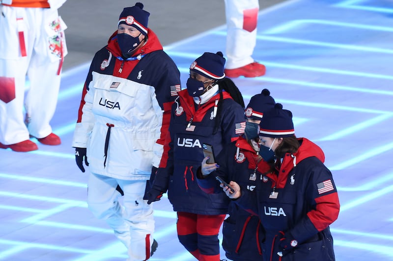 Women athletes for Team USA walk during the opening ceremony of the 2022 Beijing Olympics wearing red boots and red trousers with navy jackets, designed by Ralph Lauren. Getty Images