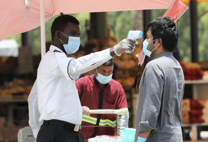 DUBAI, UNITED ARAB EMIRATES , June 9 – 2020 :- Security guard checking the temperature of the visitor at the Al Awir fruit & vegetable market during the hot and humid weather in Dubai. (Pawan Singh / The National) For News/Standalone/Online/Stock