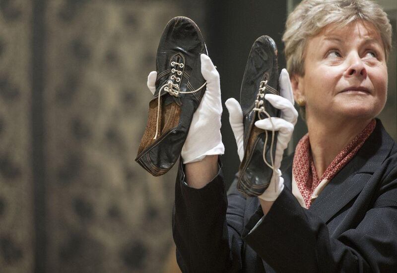 A Christie's employee holds running shoes worn by Sir Roger Bannister, which sold in the Out of the Ordinary auction at Christie’s London, Lauren Hurley / PA