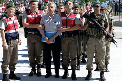 FILE - In this Aug. 1, 2017 file photo, paramilitary police and members of the special forces escort former Air Force commander Akin Ozturk and other suspects of a failed coup in 2016, outside the courthouse at the start of a trial, in Ankara, Turkey. Turkey's state-run news agency says Thursday, June 20, 2019, a court in Ankara has sentenced several people, including Ozturk, accused of being the ringleaders of the 2016 failed military coup, to life terms in prison. (AP Photo/Burhan Ozbilici, File)