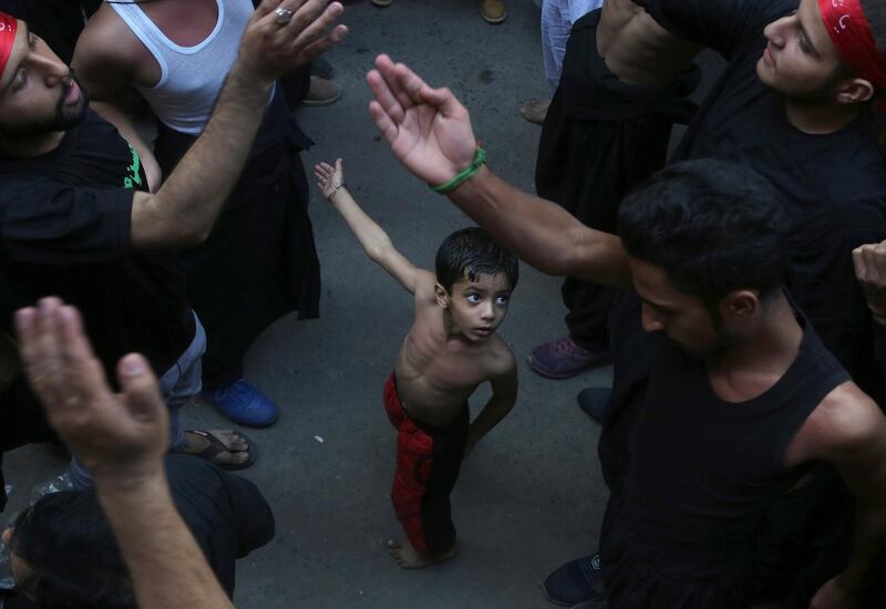 A Shiite Muslim child beats his chest next to his father during a procession to mark the end of the 40th day of Ashura. AP