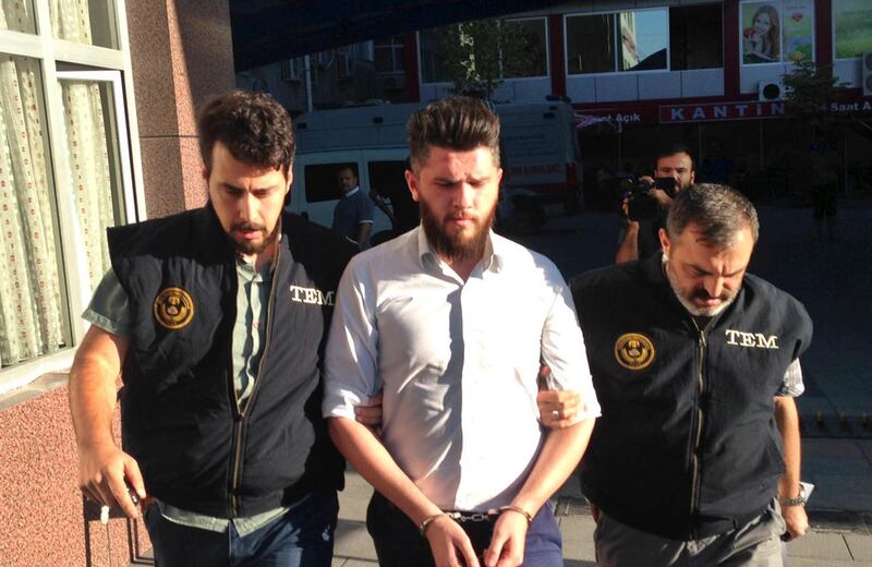 Turkish police officers escort a man arrested in a raid in Konya on Wednesday. AP / Tolga Yanik