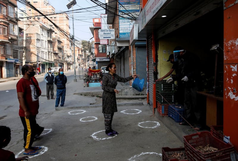 People stand on markings to maintain social distancing in Kathmandu, Nepal. Reuters