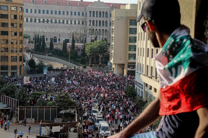 Protesters wave flags and shout anti-government slogans during a protest in front the Government palace in downtown Beirut. EPA