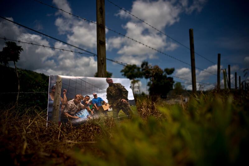A printed photograph taken on October 7, 2017 sits at the same spot where Puerto Rican National Guards delivered food and water to desperate residents. For two months, stranded residents came to this spot for supplies.