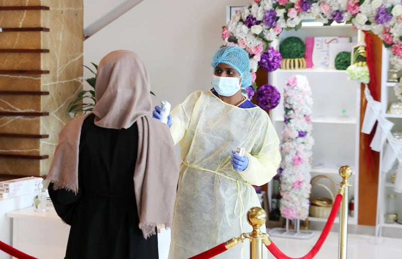 DUBAI, UNITED ARAB EMIRATES , April 26– 2020 :- Medical staff checking the temperature of the visitor at the entrance of the Prime Hospital on airport road in Al Garhoud in Dubai . (Pawan Singh / The National) For News/Standalone/Online/Instagram/Stock.  Story by Nick Webster