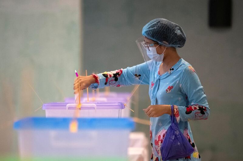 A woman wearing a protective face masks casts her ballot for the general election at a polling station in Yangon, Myanmar. Reuters