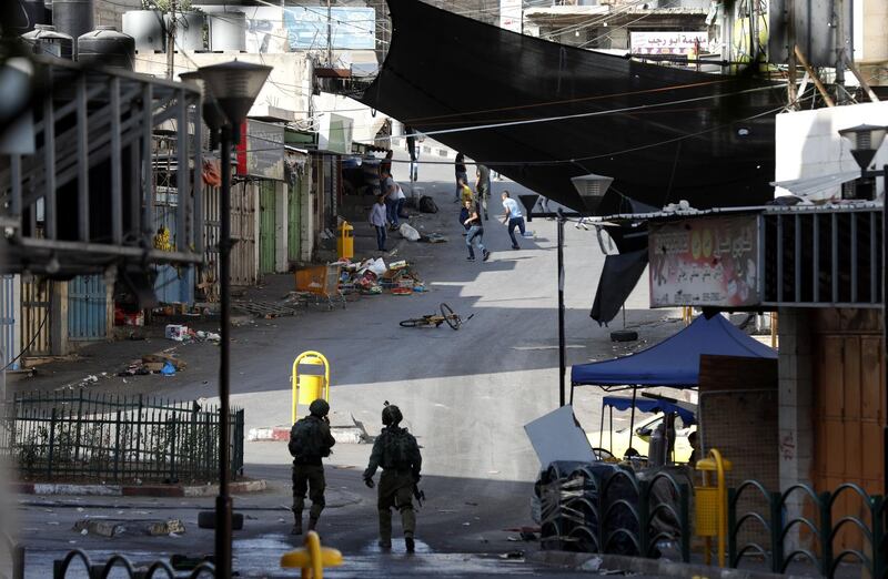 Israeli soldiers take position during clashes with Palestinian stone throwers in the West Bank city of Hebron. EPA