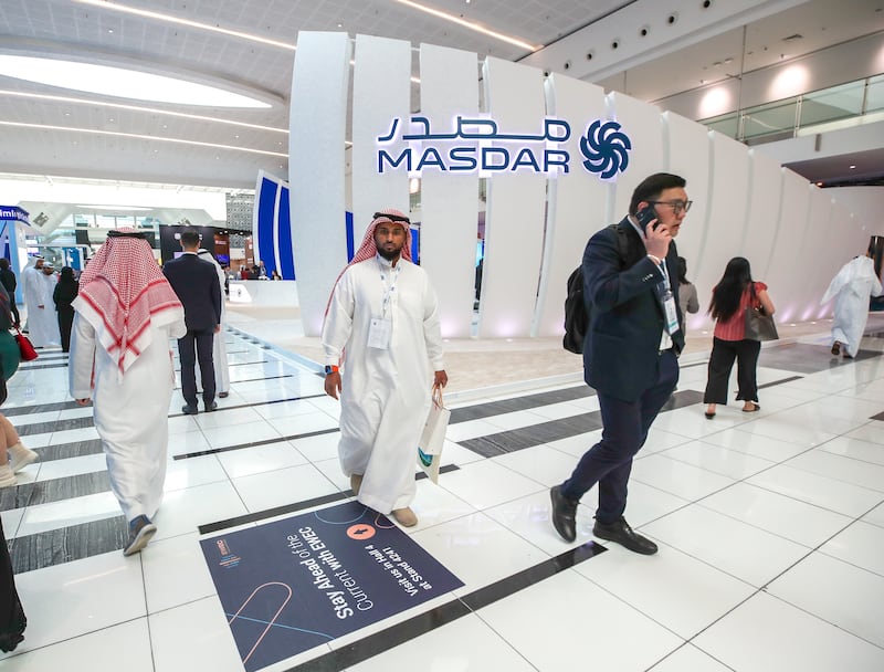 Visitors walk past the Masdar stall. Victor Besa / The National