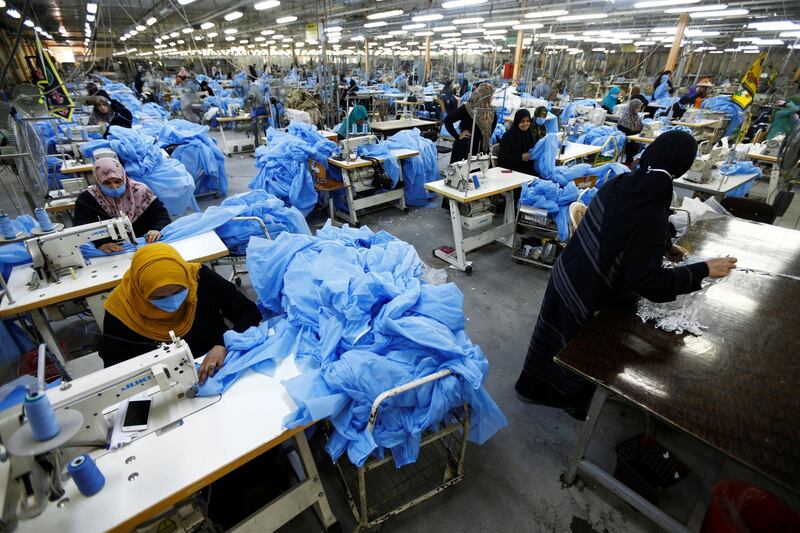 Women sew protective suits at a factory in Najaf, Iraq. Reuters