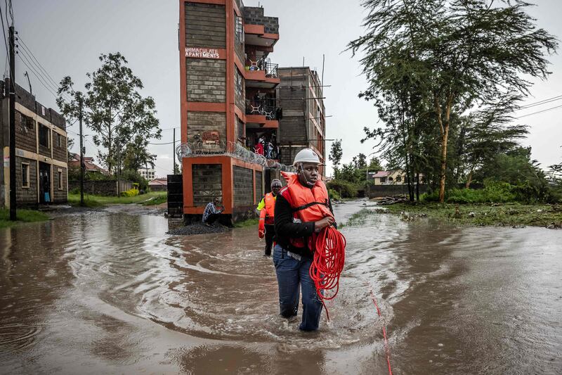 Members of the Kenya Red Cross assess an area affected by floods while looking for residents trapped in their homes after torrential rain in the Kitengela area. AFP