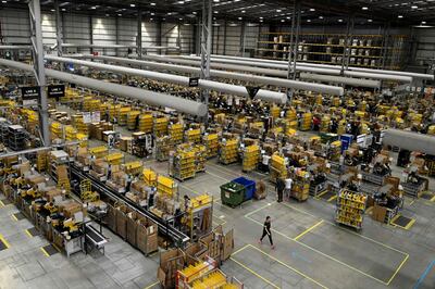 Amazon workers sort and pack items at a warehouse. AFP