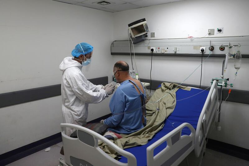 A medical worker assists a Covid-19 patient in the intensive care unit of the Rafik Hariri University Hospital in Beirut, Lebanon. AP