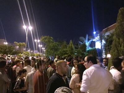 In this Thursday, June 28, 2018 photo, dozens of fans gather outside Egypt's beloved striker Mohamed Salah's home in Madinaty compound, just outside Cairo, Egypt, after his arrival with Egypt's national team from Russia following a disappointing World Cup showing. The state-run Al Ahram newspaper reported the number of fans kept increasing, reaching the hundreds, and police had to intervene to disperse the crowds. (Yehya via AP)