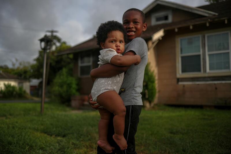 Vincent Turner, 6, holds his eight-month-old sister Faith while playing in the front yard of their home ahead of the arrival of Hurricane Laura in Beaumont, Texas, US. Reuters
