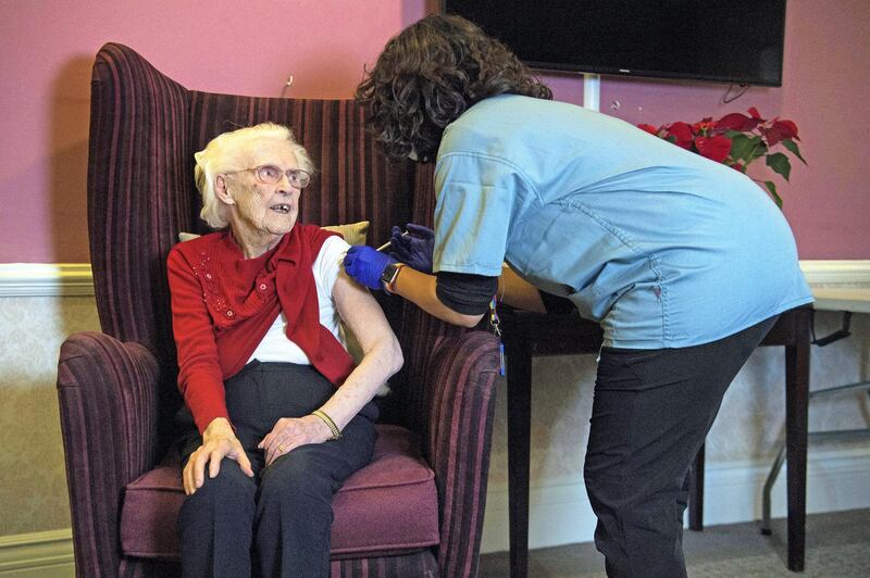 One hundred year-old Ellen Prosser, known as Nell,  receives the Oxford/AstraZeneca COVID-19 vaccine from Dr Nikki Kanani at the Sunrise Care Home in Sidcup, south east London on January 7, 2021. - A mass rollout by GP practices of the Oxford/AstraZeneca Covid-19 vaccine has begun, as hospitals across the United Kingdom face rising numbers of seriously ill patients. (Photo by Kirsty O'Connor / POOL / AFP)