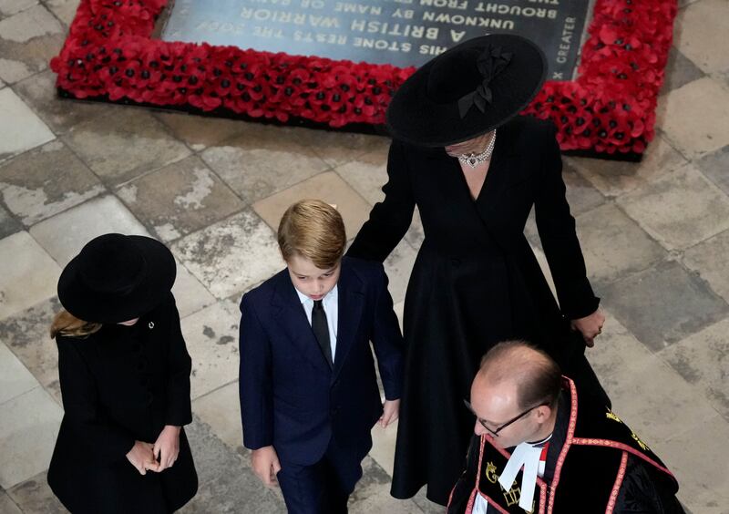 The Princess of Wales wears a black Alexander McQueen coat dress, after donning the white version for the queen's birthday celebrations in June. AP