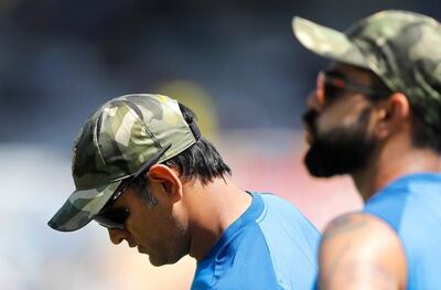 India's captain Virat Kohli, right, and teammate Mahendra Singh Dhoni sport camouflage caps before the start of the third one day international cricket match between India and Australia in Ranchi, India, Friday, March 8, 2019. Members and the support staff of Indian cricket team wore camouflage caps as a mark of tribute to the paramilitary soldiers killed in suicide car bombing in Indian controlled Kashmir last month. (AP Photo/Aijaz Rahi)