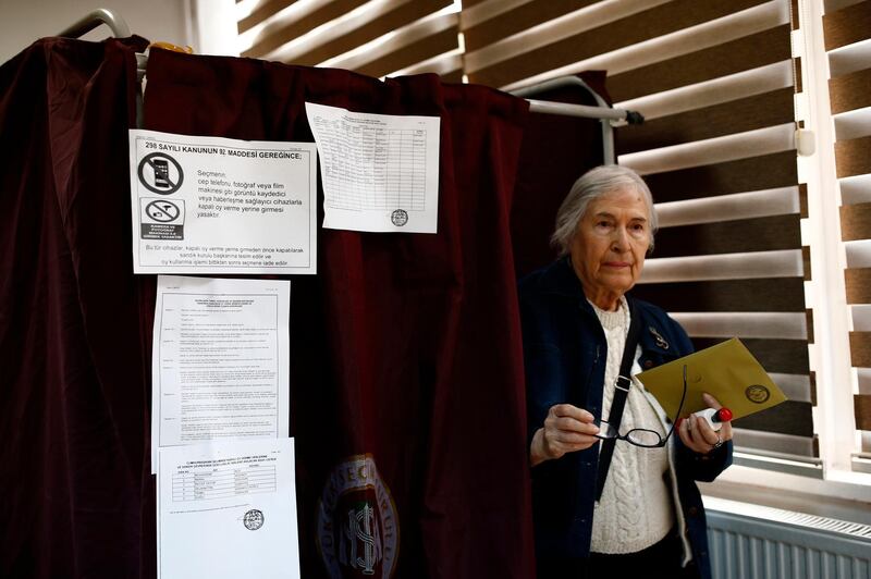 A voter leaves a booth with ballot papers at a polling station at a primary school in Ankara, Turkey, on June 24, 2018. Burhan Ozbilici  / AP Photo