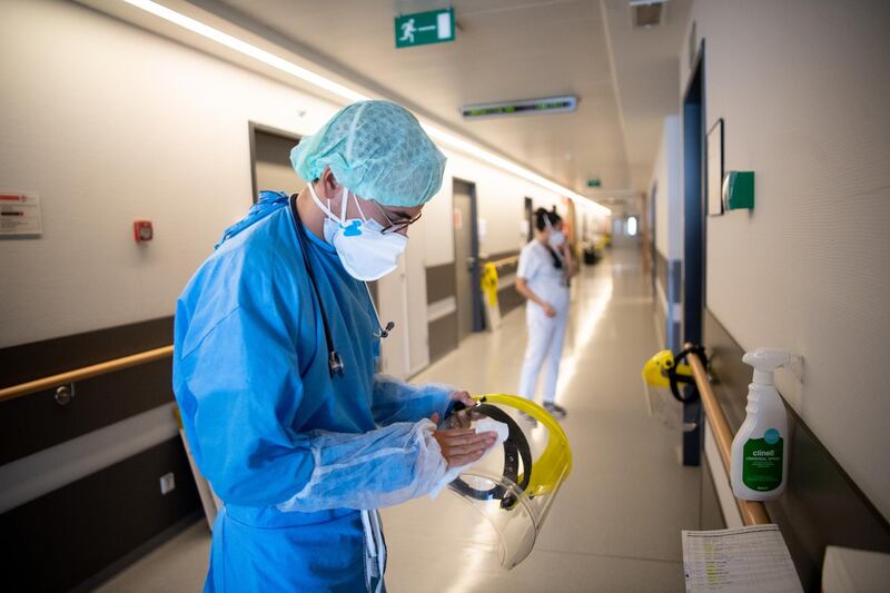 A doctor wipes his protective visor after visiting a Covid-19 room. Getty Images