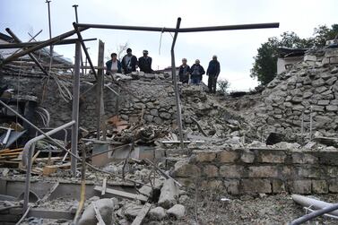 Men look at the damage in a residential area after shelling by Azerbaijan's artillery during a military conflict in self-proclaimed Republic of Nagorno-Karabakh, Stepanakert, Azerbaijan. AP