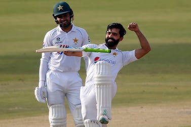 Pakistan's Fawad Alam, right, celebrates after scoring century while his teammate Faheem Ashraf watches during the second day of the first cricket test match between Pakistan and South Africa at the National Stadium, in Karachi, Pakistan, Wednesday, Jan. 27, 2021. (AP Photo/Anjum Naveed)