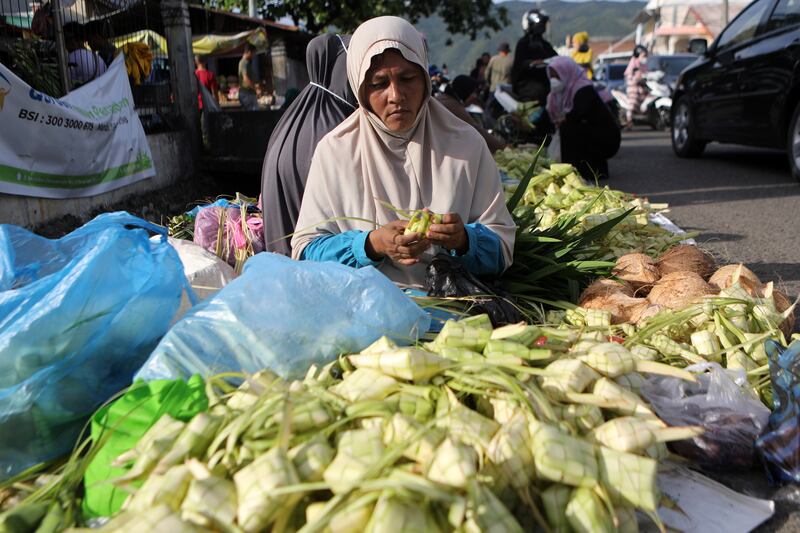 A woman sells traditional plaited coconut leaf pouches for ketupat rice cakes, ahead of Eid Al Adha in Banda Aceh, Indonesia. EPA