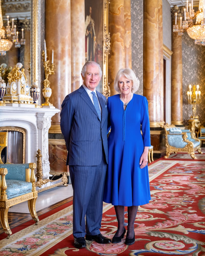 King Charles III and the queen consort, wearing a blue wool crepe coat dress by Fiona Clare, in a portrait released in April 2023 ahead of the coronation. Reuters