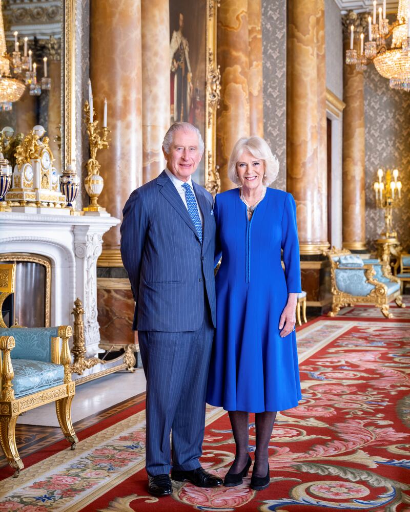 King Charles III and the queen consort, wearing a blue wool crepe coat dress by Fiona Clare, in a portrait released in April 2023 ahead of the coronation. Reuters