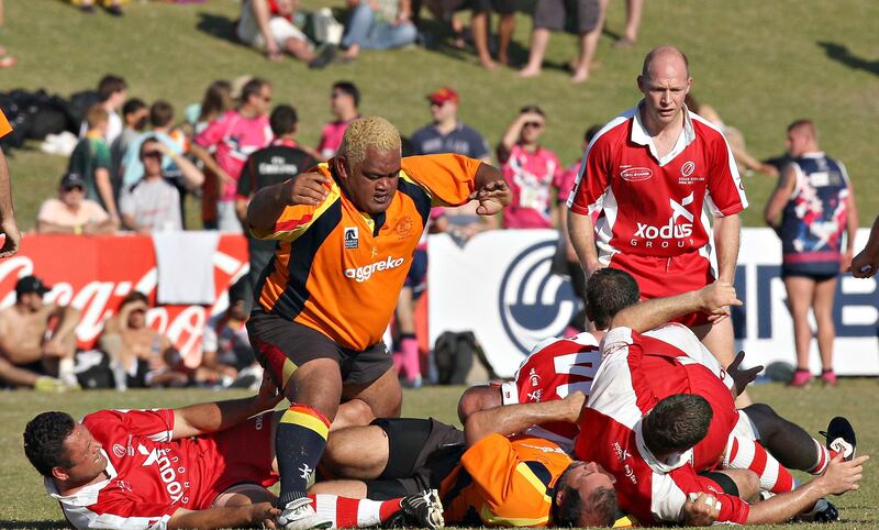 Dubai , United Arab Emirates, Dec 3 2011, International Vets Championship, Sports Reporter Paul Radley  story- (left centre orange kit)Christina Noble Childrens Foundations's Trevor Leota makes his way out of pile of players during action at the Emirates airlenes Dubai Rugby Sevens. Mike Young / The National

