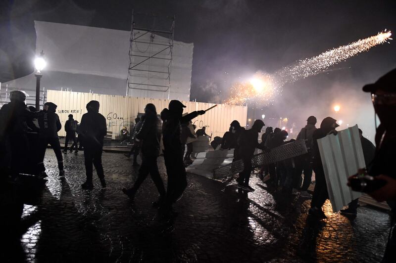 A protester shoots a firework towards police officers at Place de la Concorde in Paris. AFP