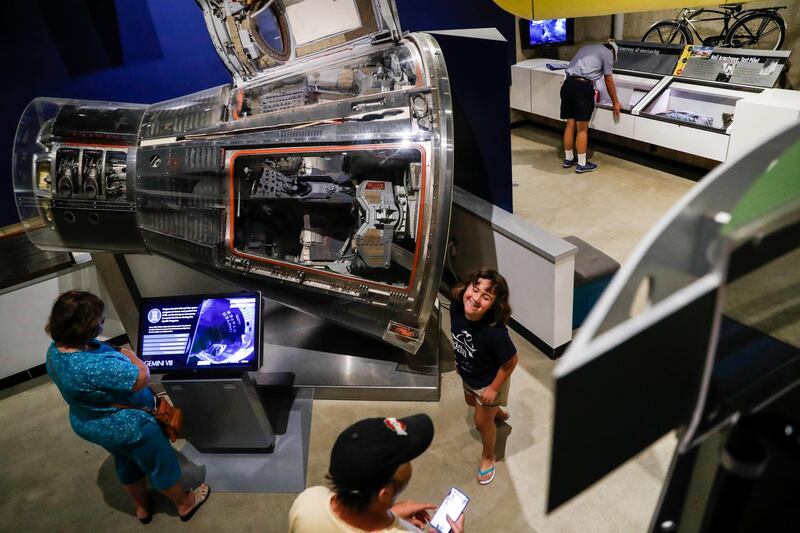 Visitors browse an exhibit featuring the Gemini VIII spacecraft.