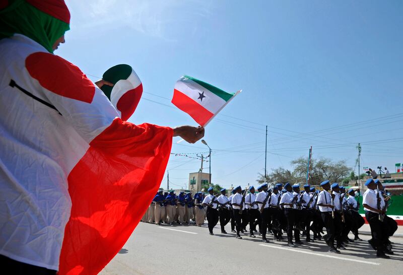 (FILES) This file photo taken on May 18, 2016 shows a woman waving a flag as soldiers and other military personnel of Somalia's breakaway territory of Somaliland march past during an Independence day celebration parade in the capital, Hargeisa.  
The self-proclaimed state of Somaliland will vote for a new president on November 13, 2017, hoping to continue a series of democratic transitions of power that sets it apart from its troubled neighbour Somalia. The northern territory, which is more tribally homogenous and stable than the rest of Somalia, broke away in 1991 and has been striving to attain international recognition ever since.
 / AFP PHOTO / MOHAMED ABDIWAHAB