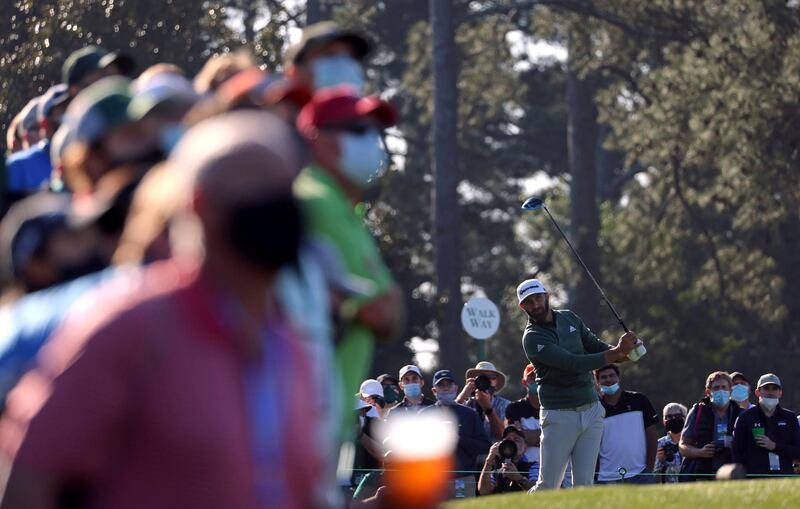 Dustin Johnson hits his tee shot on the first hole during a practice round ahead of the Masters as hundreds of fans watch on. Reuters