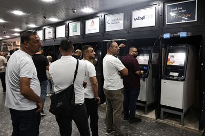 Palestinians queue to withdraw money from ATMs at a bank in the city of Nablus. AFP