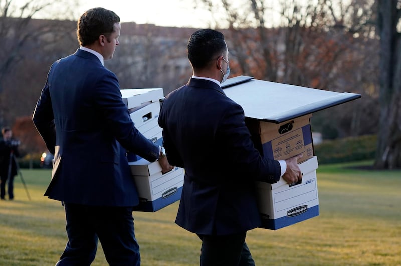 Aides carry boxes to Marine One before President Donald Trump leaves the White House. AP Photo