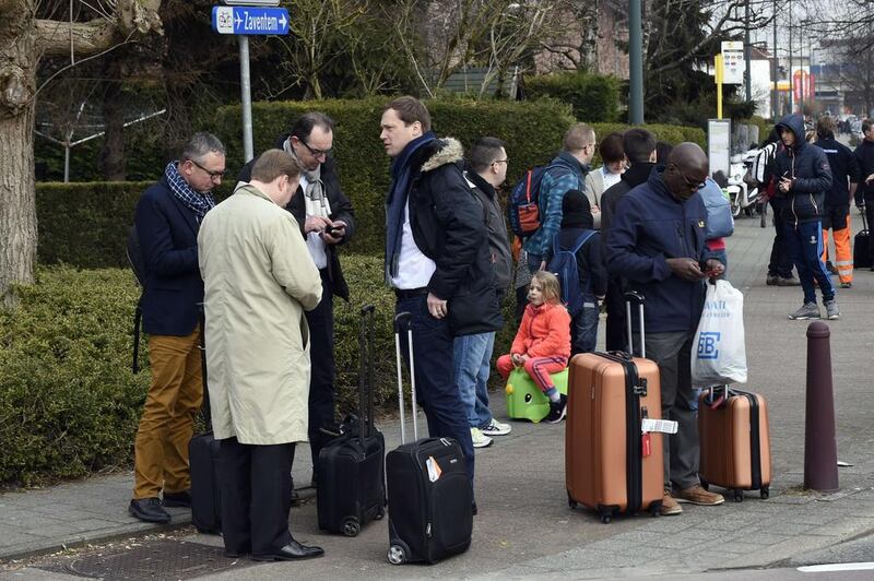 Passengers are gathered near Brussels airport, following its evacuation after at least 13 people were killed and 35 injured, according to local media, as twin blasts rocked the main terminal of Brussels airport. John Thys / AFP