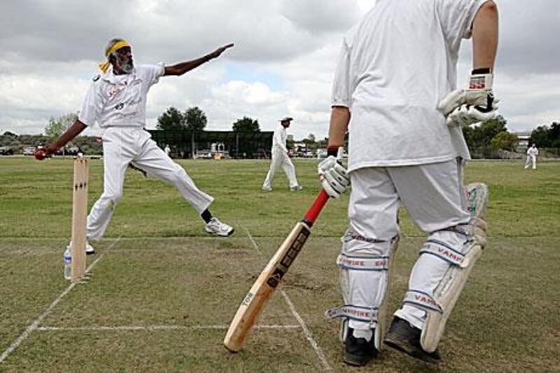 Ted Hayes, co-founder, player and coach of the Compton Cricket Club, bowls against the Simi Sluggers.