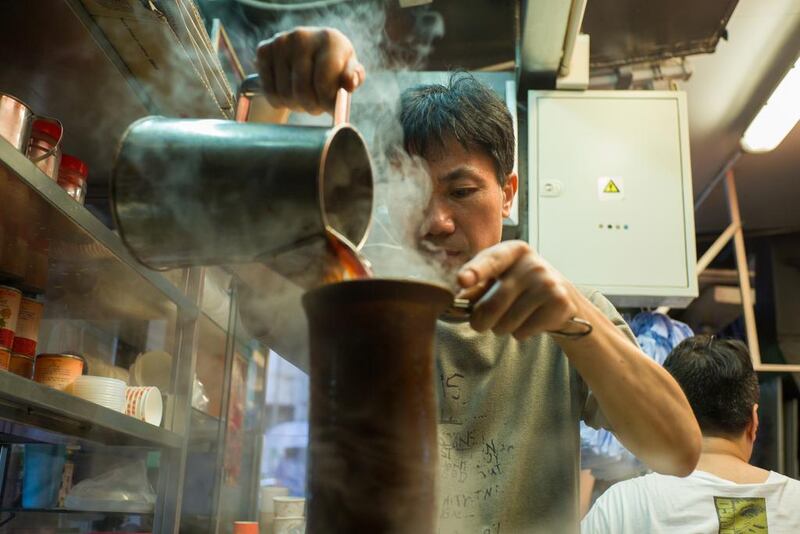 A tea master makes a milk tea at a family-run tea shop Lan Fong Yuen, in Hong Kong’s Central district. Anthony Wallace / AFP Photo