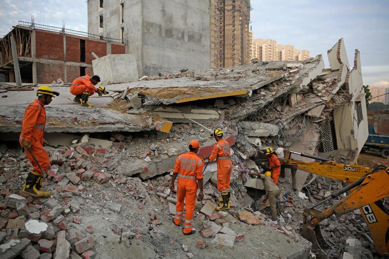 Rescuers search survivors at the site of a collapsed building. AP Photo