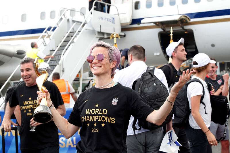 United States women's soccer team member Megan Rapinoe holds the Women's World Cup trophy after arriving with teammates at Newark Liberty International Airport, Monday, July 8, 2019, in Newark, N.J. (AP Photo/Kathy Willens)