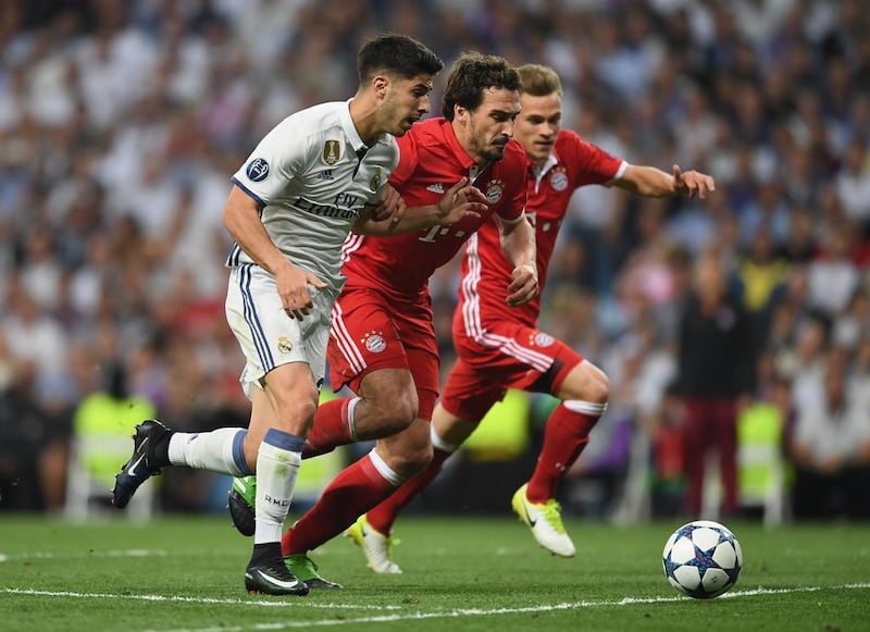Marco Asensio of Real Madrid beats Mats Hummels of Bayern Munich to score their fourth goal. Shaun Botterill / Getty Images