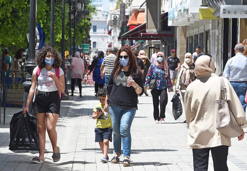 Tunisian people wearing protective face masks walk in the Habib Bourguiba avenue in Tunis.  AFP
